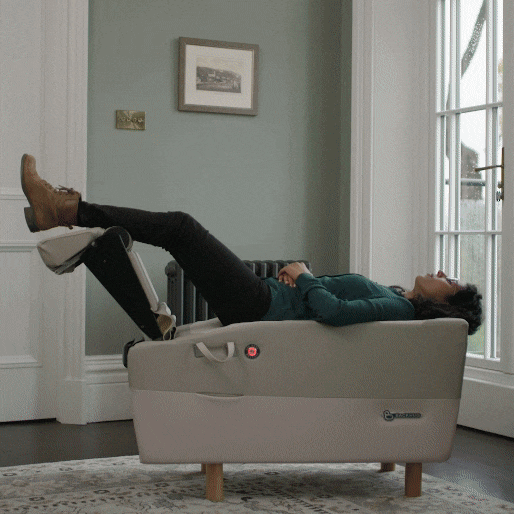 Person reclining on angled therapy chair by window